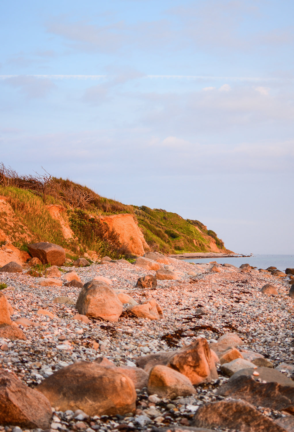 Vitsø kystlinje med store sten i forgrunden Lyset på billedet falder fint og lyser hver en sten op i varme farver.