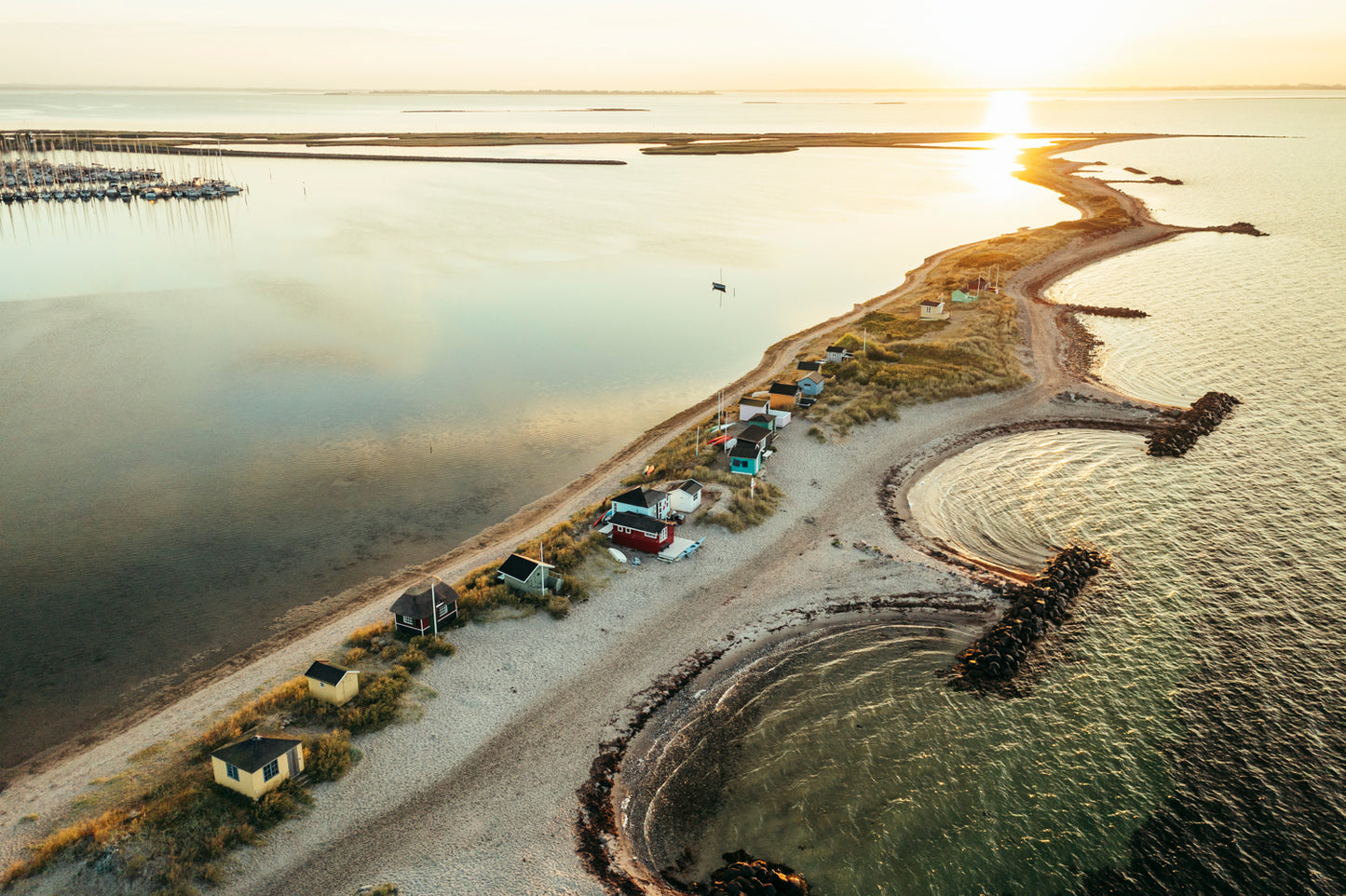 Eriks Hale strand i Marstal på Ærø med solopgangen i baggrunden og man kan lige skimte lystbådehavnen