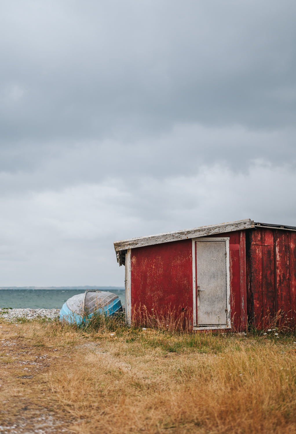 Et råt rødt fiskerhus på Vitsø strand nær Søby på Ærø